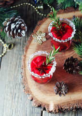 glass of hot mulled wine for the new year with ingredients for cooking, nuts and Christmas decorations