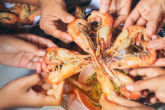 People Are  Eating  Grilled Shrimp With Fun And Happy In Holiday.