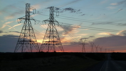 Sunset, Rows of pylons, Power lines, Wind turbines, Texas