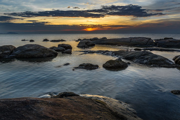 Rocks in the sea with sunset sky.