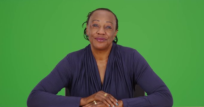 An African American businesswoman talks to the camera on green screen. On green screen to be keyed or composited. 