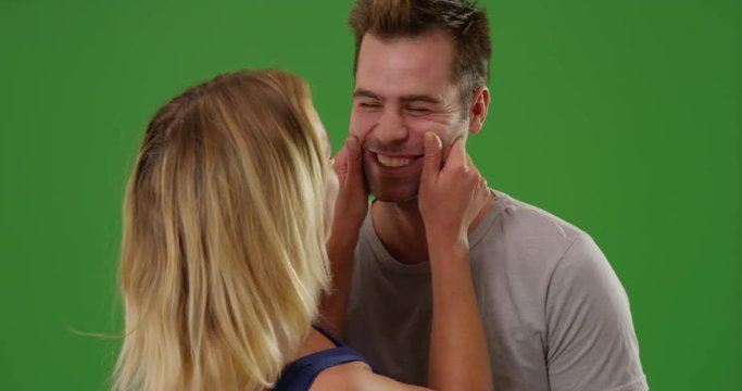 Funny millennial couple being silly and laughing at camera on green screen. On green screen to be keyed or composited. 