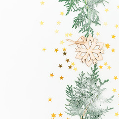 New Year composition made of fir branches, decoration with golden confetti on white background. Flat lay, top view