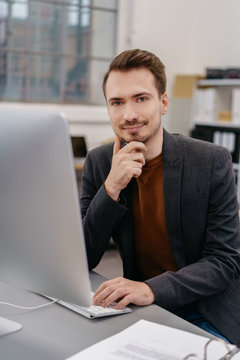 Young man sitting at desk in front of computer