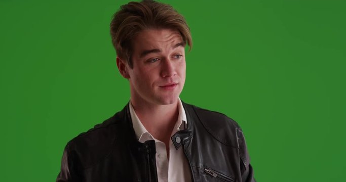 Attractive young Caucasian male waiting nervously for date to arrive on green screen. On green to be keyed or composited. 