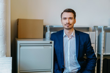Fototapeta premium Man leaning against storage cabinet in office