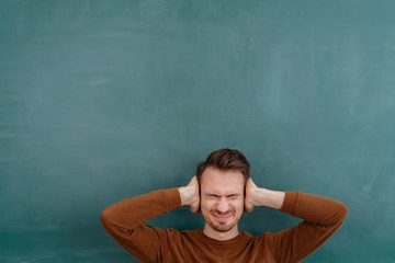 Frustrated man covering his ears with his hands