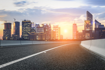 Asphalt highway and modern city buildings in hangzhou qianjiang new city at sunset