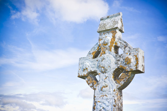 Celtic carved stone cross against a sky background - image with copy space