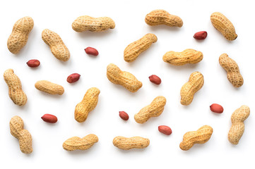 Creative peanut pattern. Isolated unpeeled groundnut and kernels. Top view.