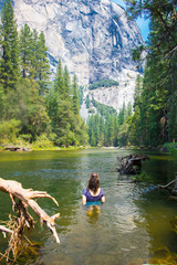 teen girl swims in mountain lake in yosemite park one of the sights that you should have seen in America