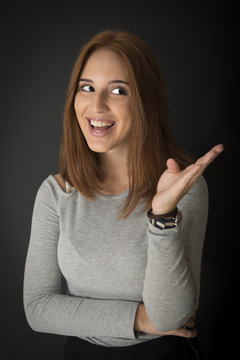 Portrait of a red hair young girl on black background. Half length.