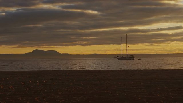 Silhouette two-masted yacht at the beautiful sunset on the sea