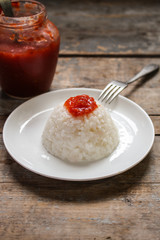 boiled round rice on a white plate, on a wooden surface