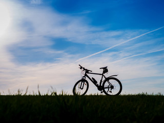 Naklejka na ściany i meble Bicycle silhouettes on the dark background of sunsets