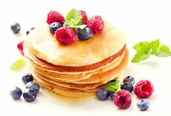 pancakes with raspberries and blueberies on a white plate