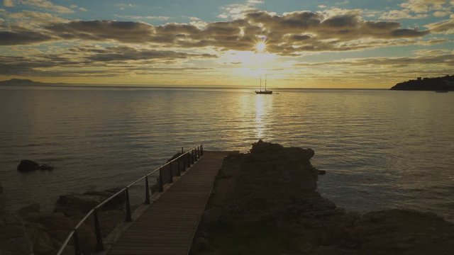Silhouette two-masted yacht at the beautiful sunset on the sea
