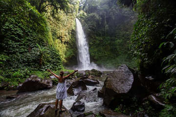 Woman at the giant Nungnung waterfall on Bali island, Indonesia