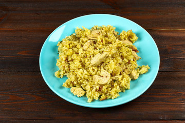 Indian biryani with chicken, yogurt and spices in a plate on a wooden table. New Year's, Christmas dish.