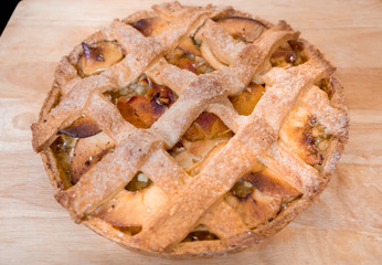 Macro photography of tasty apples and persimmons tart on wood cutting board