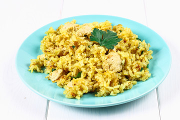 Indian biryani with chicken, yogurt and spices in a plate on a wooden table. New Year's, Christmas dish.