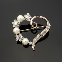 brooch heart with diamonds and pearls isolated on black