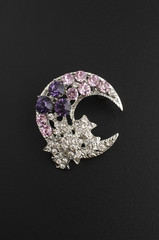 silver brooch month with stars with diamonds isolated on black