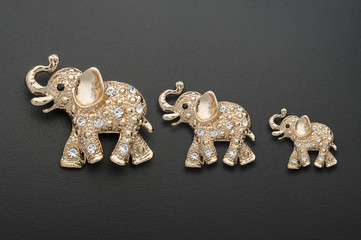 family of golden elephants, mom dad child isolated on black