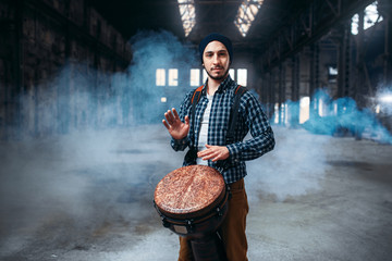 Male drummer playing on wooden drum