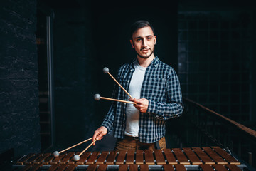 Fototapeta premium Young male xylophone player with sticks in hands