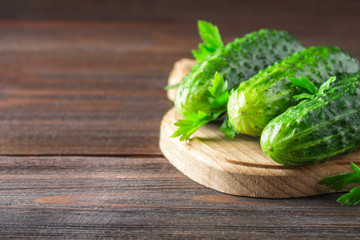 Fresh raw green cucumbers on a wooden table.