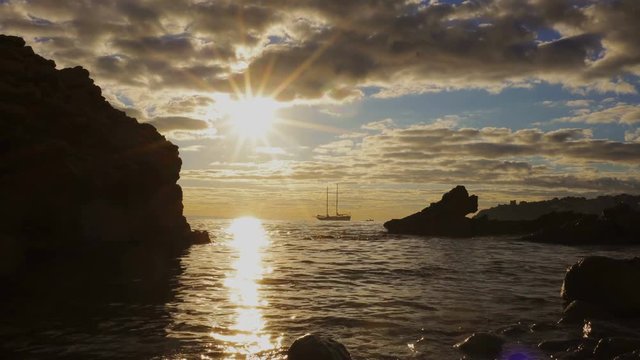 Silhouette two-masted yacht at the beautiful sunset on the sea