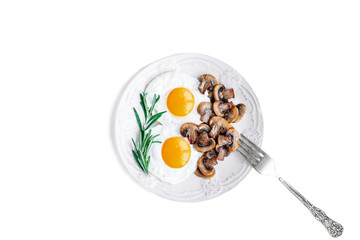 Vegetarian breakfast with fried eggs and mushrooms decorated with a sprig of rosemary on a white background.Top view