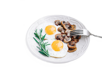 Vegetarian breakfast with fried eggs and mushrooms decorated with a sprig of rosemary on a white background.Top view