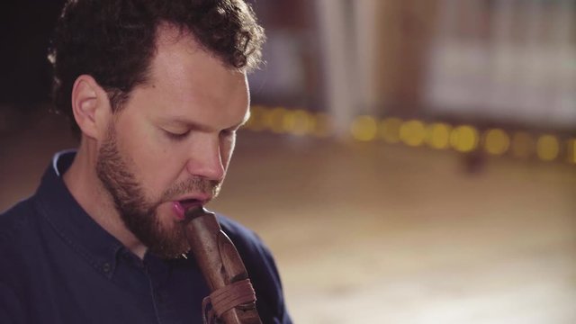 Close up portrait of musician playing ethnic flute