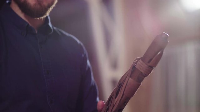 Close up hands of musician playing ethnic flute