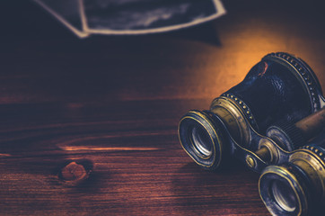 Old opera glasses on wooden background