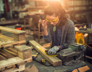 Close up view of hardworking focused professional serious carpenter woman working with a ruler and...