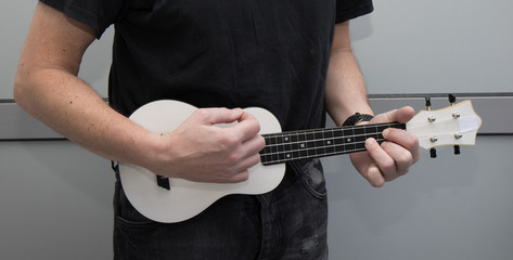 A man plays ukulele