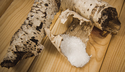 Xylitol - sugar substitute. Birch sugar on wooden background.