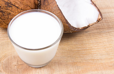 Coconut with coconut milk on wooden background.