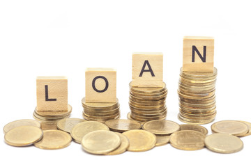 Word Loan Concept on wooden block over on stacked coins.