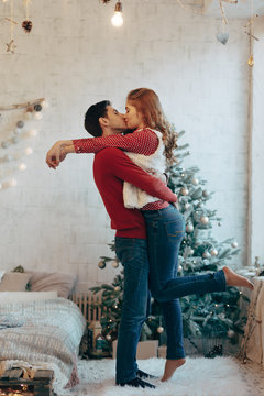 Picture showing young couple hugging and kissing over Christmas 