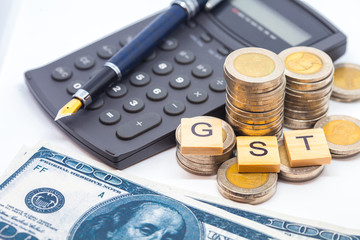 Fototapeta premium Goods and Services Tax word on stack coins isolate .