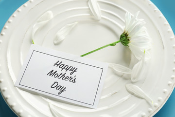 Flower and card with text HAPPY MOTHER'S DAY on plate