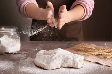 Woman preparing puff pastry on table