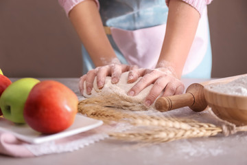 Woman preparing puff pastry on table