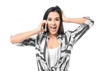 Emotional young woman speaking by mobile phone on white background