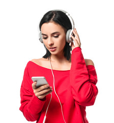 Beautiful young woman with mobile phone listening to music on white background