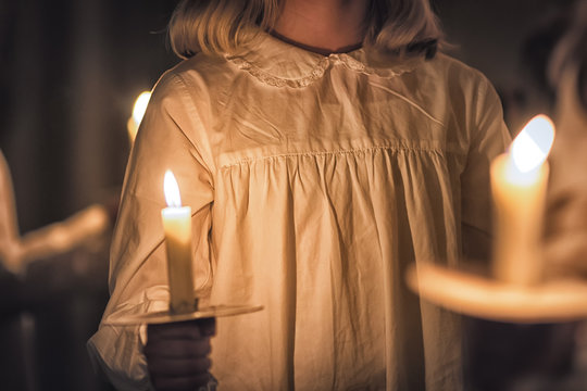 Kids Are Handling Candles In The Traditionall Dresses. Celebration Of Lucia Day In Sweden.